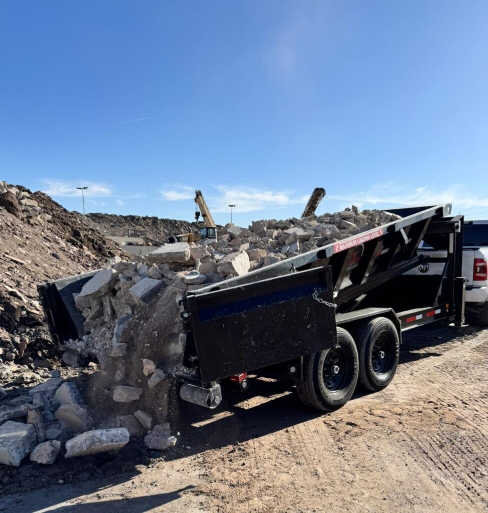 Longhorn dumpster unloading broken concrete at a transfer yard